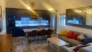 A modern kitchen with dark cabinets, a central island, and blue patterned backsplash. - A little slice of heaven! (Rosmuc)