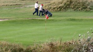 A golf course with a flagstick, a cart, and two people walking. - Small Cozy Nest for 4 People 100 m From the Beach Free Parking (De Haan)