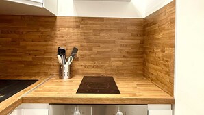 Eine Küche mit Holzausstattung, einem eingebauten Backofen und einer Dunstabzugshaube.
