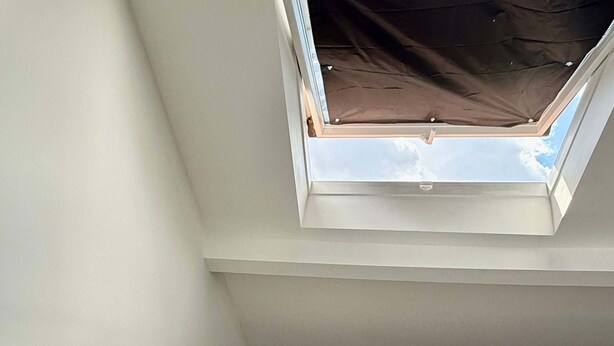 A bedroom with a skylight, a bed, a bedside table, and a lamp. - Doux nid Perche Avec vue Magique sur la Ville (Brussels)