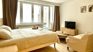 Une chambre d’hôtel avec un lit, une télévision, un bureau et une chaise.