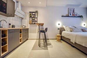 Ein gemütlicher Raum mit Küchenzeile, einem Bett und einem kleinen Tisch.