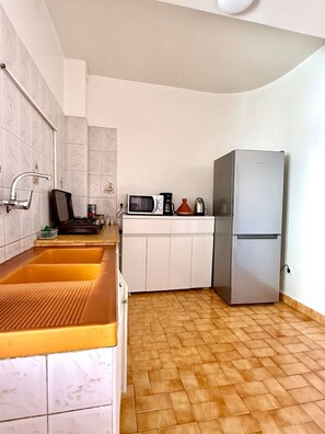 Eine Küche mit Spüle, Mikrowelle, Wasserkocher und Kühlschrank.