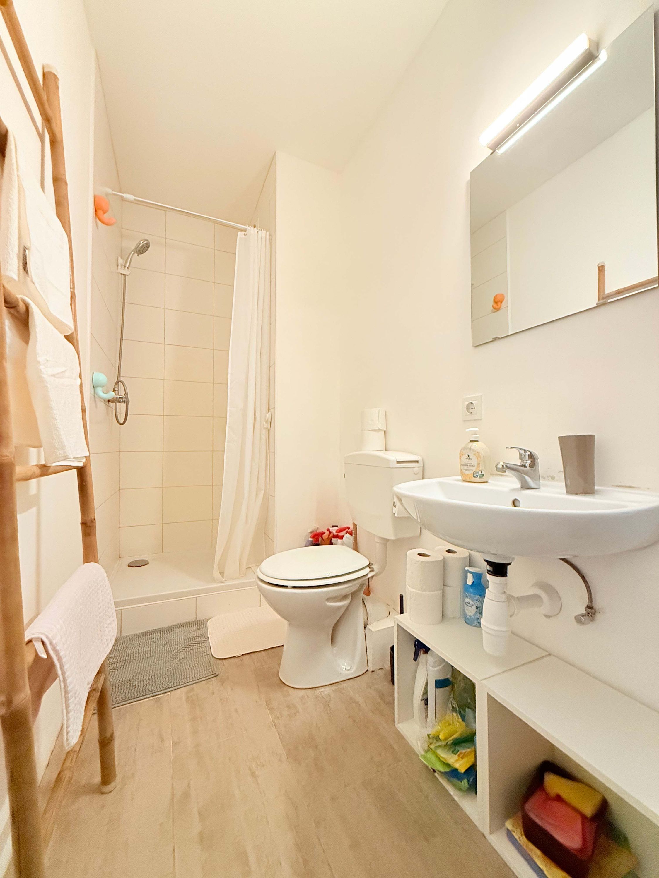 Ein Badezimmer mit Dusche, Toilette, Waschbecken und Spiegel.