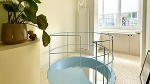 Un intérieur moderne avec un escalier en colimaçon, une plante en pot et une fenêtre offrant une belle vue.