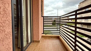 A balcony with a wooden floor, a black railing, and a view of the sky and buildings. - Villa With Pool Rooftop Near Amelkis and Al Maaden Golf Courses Route de Ouarzazate Area (Marrakech)
