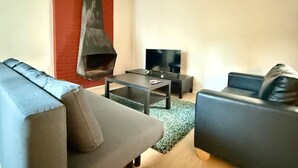 A modern living room with a fireplace, a flat-screen TV, and two sofas. - 3 min to the Grand-place 6 min to Manneken Pis Sleeps 6 (Brussels)