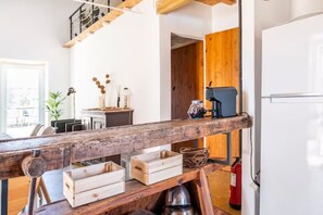 Une cuisine avec des poutres en bois, une machine à café et un extincteur.