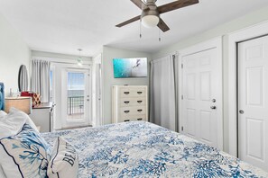 A bedroom with a bed, a ceiling fan, a TV, a dresser, and a door. - ⭐BEACH FRONT-3 Gulf Front Balconies-3BR The Q⭐ (Miramar Beach)