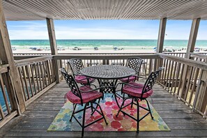 A wooden deck with a round table and chairs, overlooking a beach. - ⭐BEACH FRONT-3 Gulf Front Balconies-3BR The Q⭐ (Miramar Beach)