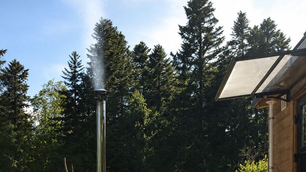 A hot tub with a steam vent, a swing chair, and a wooden deck.