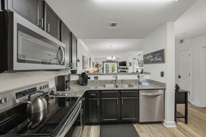 A modern kitchen with a stainless steel refrigerator, microwave, and stove. - Poolside Bear Escape Indoor and Outdoor Fun (Pigeon Forge)