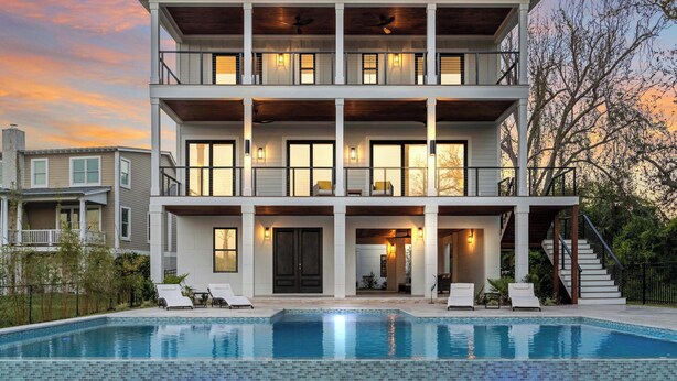 Une maison à plusieurs étages dotée d’une piscine, de balcons et d’un escalier.