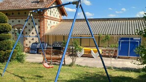 Ein Wohngebiet mit einem Ziegelhaus, einer Schaukel und einer blauen Tür.