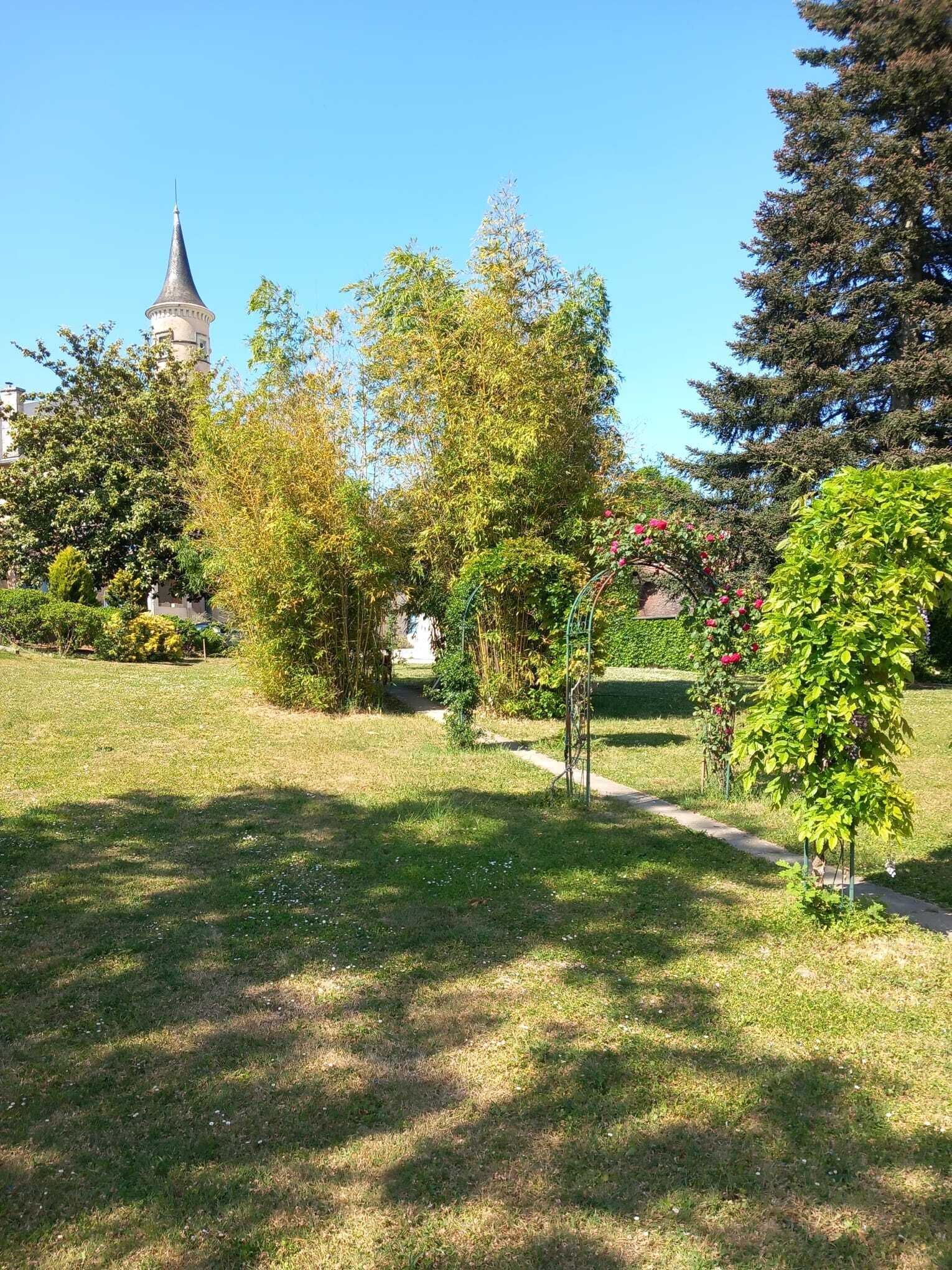 Un parco con una torre, alberi e un sentiero.