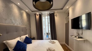 Ein Hotelzimmer mit Bett, Fernseher und Blick ins Freie.