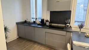 Eine moderne Küche mit einer großen Kochinsel, eingebauten Geräten und Blick durch die Fenster.