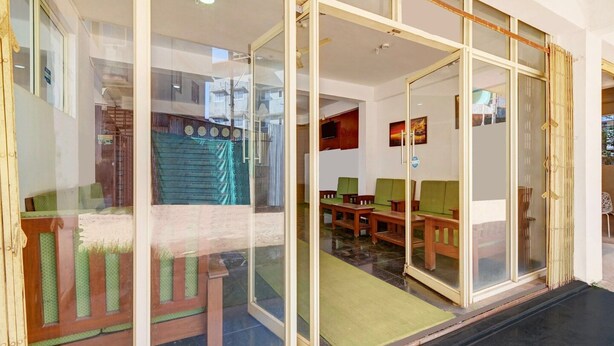 A room with a glass partition, wooden furniture, and a green mat. - Classic With Balcony Madikeri (Madikeri)