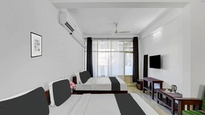 A hotel room with two beds, a TV, a desk, and a chair. - Classic With Balcony Madikeri (Madikeri)
