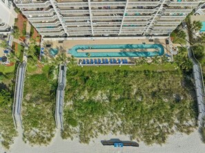 A high-rise hotel with multiple balconies, a swimming pool, and a beach area. - Crescent Shores 1007 - Oceanfront Pool (North Myrtle Beach)
