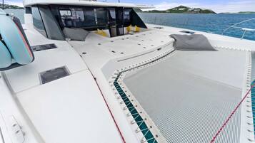 A boat deck with seating, a control station, and a view of the water.