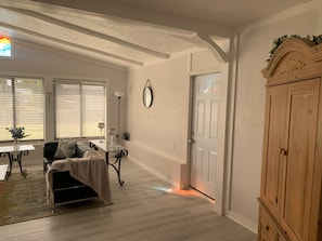 A room with a bed, a table with two wine glasses, a lamp, a mirror, and a door. - Bring your motorboat: Simple Old Florida Style Home (Englewood)