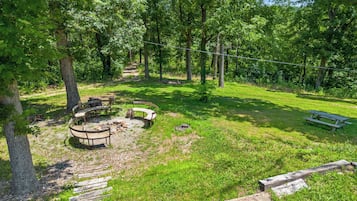 Un parque con zona de picnic, bancos y un hogar para fuego.
