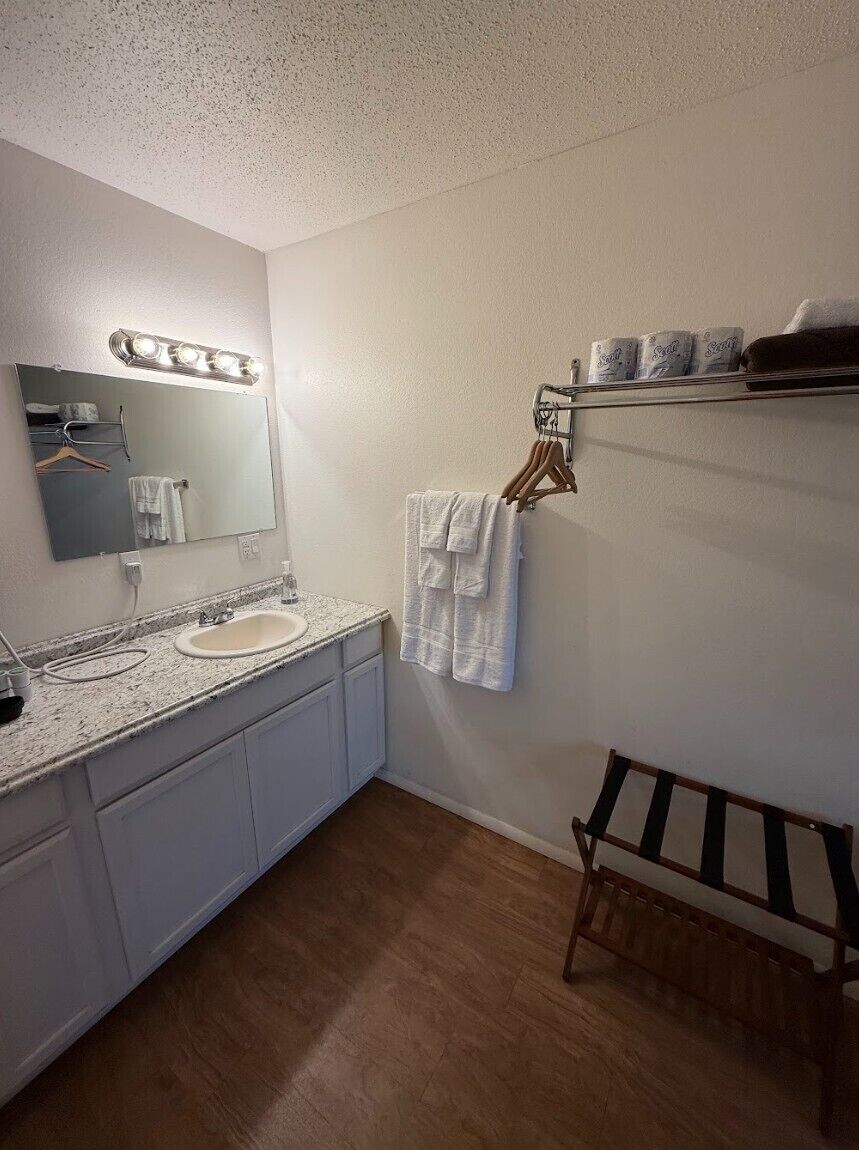 Une salle de bain équipée d’un lavabo, d’un miroir et d’un porte-serviettes.