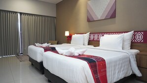A hotel room with two beds, a large window with curtains, a wall-mounted artwork, and a nightstand with a lamp. - Patra Parapat Hotel (Parapat)