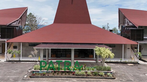 Un bâtiment avec un toit rouge et le mot « PATRIA » écrit en lettres vertes.
