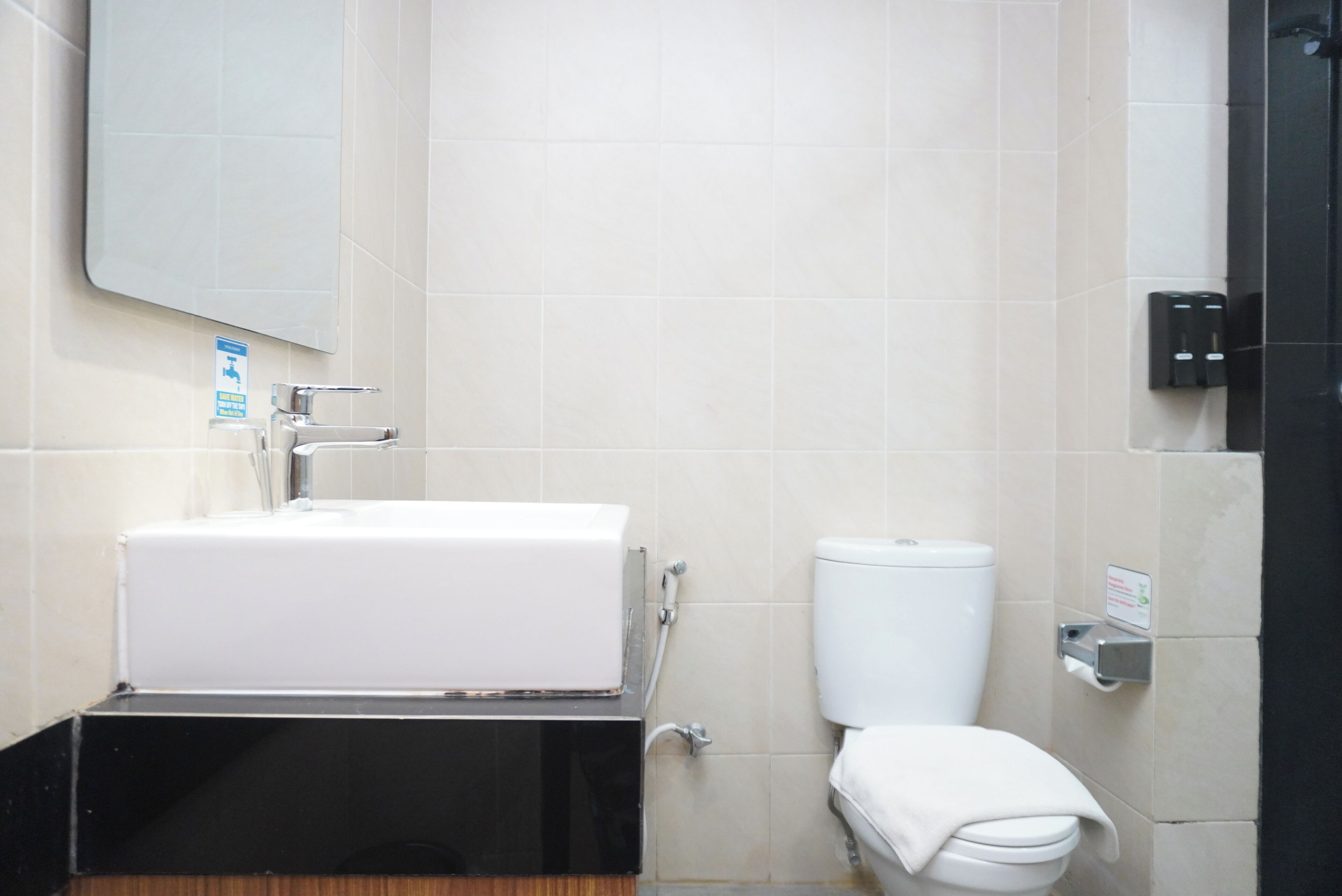 Ein Badezimmer mit einem weißen Waschbecken, einer Toilette und einem Spiegel.