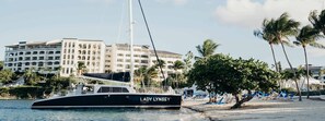 A yacht named 'Lady Lynsey' docked at a beach with a hotel in the background. - Luxury Ritz Carlton Spacious 3-bedroom condo Top Floor in beautiful St Thomas (St Thomas)