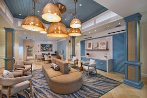 A spacious lobby with a curved sofa, multiple chairs, a dining area, and a kitchen counter. - Luxury Ritz Carlton Spacious 3-bedroom condo Top Floor in beautiful St Thomas (St Thomas)