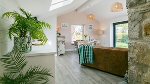 Ein modernes Interieur mit Essbereich, einer Couch und einem großen Fenster.