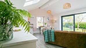Eine moderne Küche mit Essbereich, einem großen Fenster und einer gemütlichen Sitzecke mit braunem Sofa.