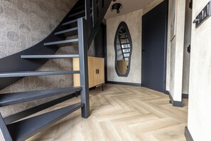 Ein modernes Interieur mit Treppe, Fischgrätparkett und einem außergewöhnlichen Wanddesign.