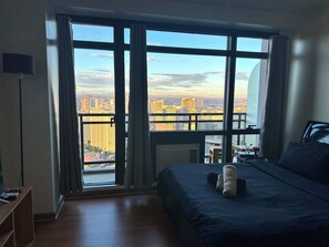 A bedroom with a large window, a bed, a desk, and a chair. - The Gramercy Residences-58th floor w/balcony+Skyline view (Makati)