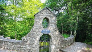 A stone structure with a plaque, a metal gate, and a stone pathway. - Bron Eifion Pod 3 (Criccieth)