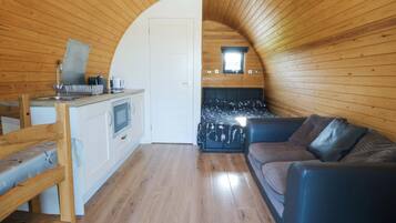 A compact interior with a kitchenette, a bed, and a seating area.