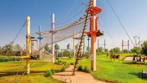A rope bridge, wooden poles, and a grassy area with a clear sky. - Comfortable apartment at Vizir Center Parc (Marrakech)