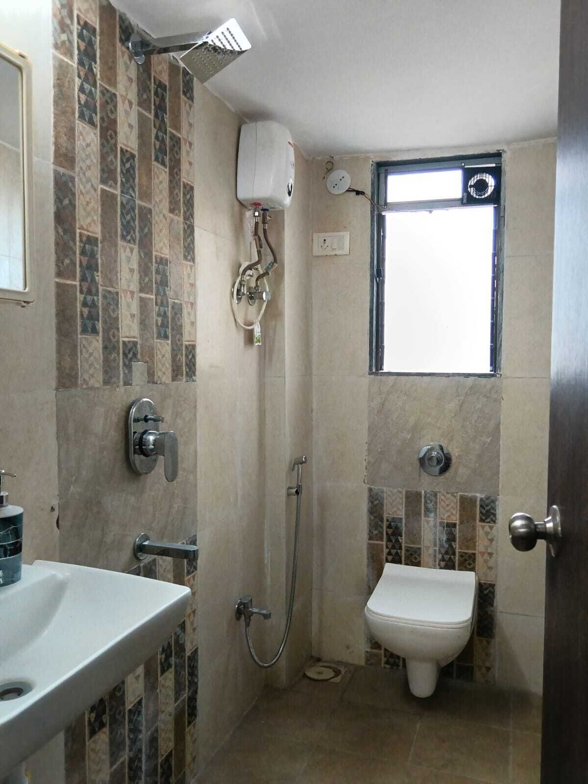 A small bathroom with a toilet, shower, and sink.