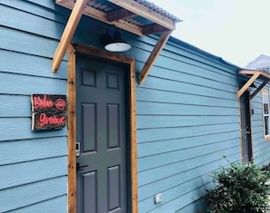 Un edificio de color azul oscuro con una puerta de madera y un cartel que dice 'Beto Groove'.
