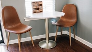 A room with two brown leather chairs, a white table, and a wooden game box on the table. - Moody Blues Studio Perfect for Work or Romance (Memphis)