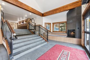 A staircase with wooden railings and a red carpet with 'RAILS END' text. - Breck Base Condo with Pool + Hot Tub (Breckenridge)