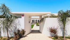 A gated entrance to a building with a clear pathway leading to a covered outdoor area. - Villa Jannah -Luxury Halal Retreat (Quinta do Anjo)
