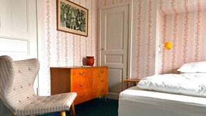 A room with a bed, a chair, a dresser, and a door. - 7 Person Holiday Home in Virserum (Virserum)