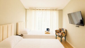 A hotel room with two beds, a television, a window with curtains, and a chair. - Kein Hotel (Durres)