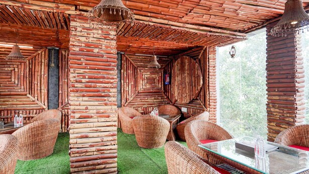 A rustic wooden interior with wicker furniture and a glass table.