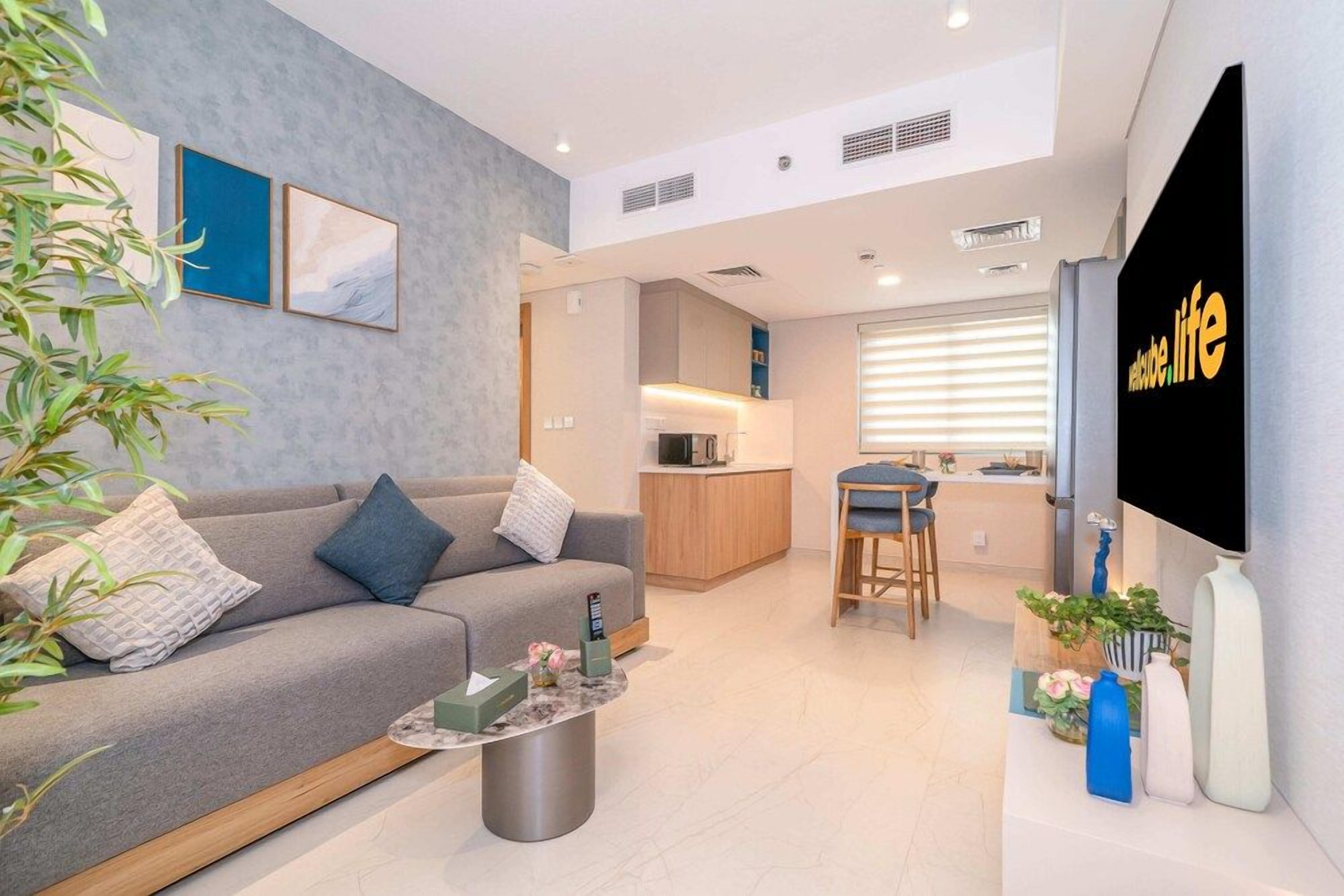 A modern living room with a sofa, coffee table, and a flat-screen TV.