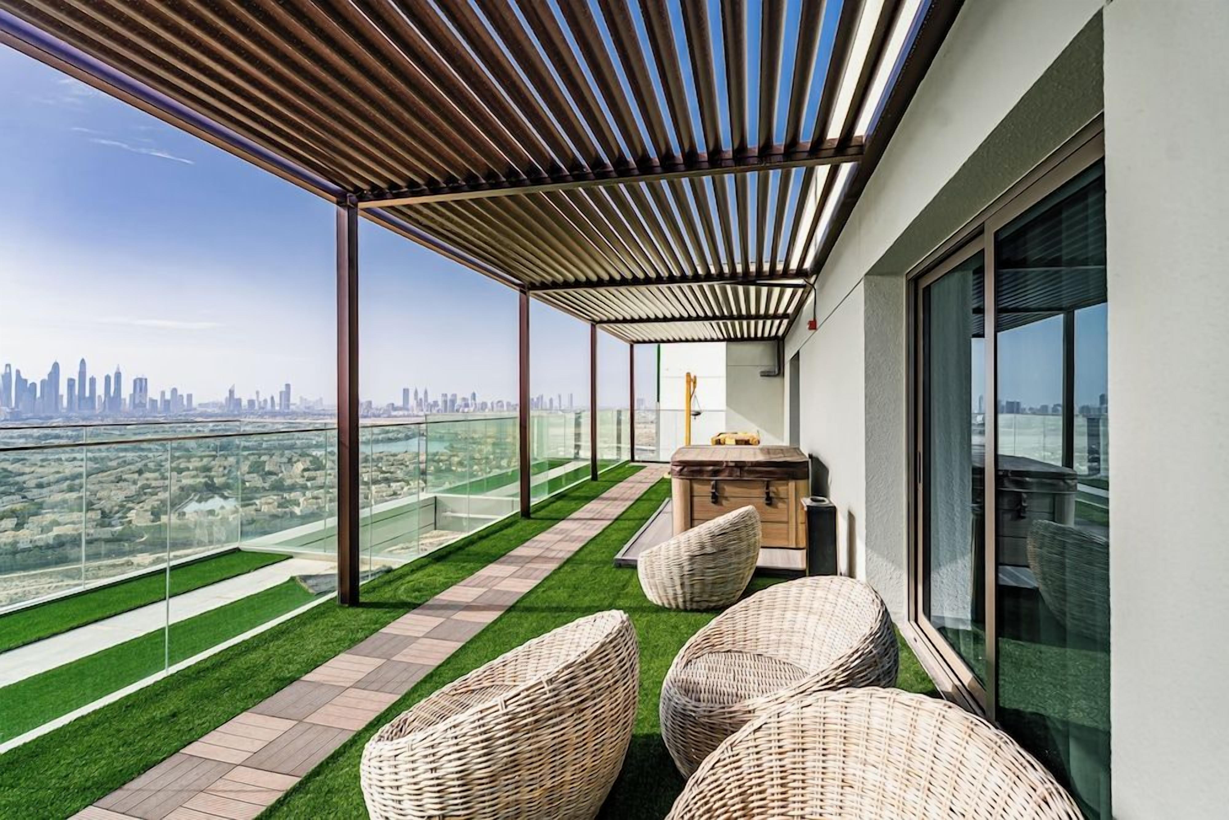A rooftop terrace with a city view, outdoor seating, and a pergola structure.